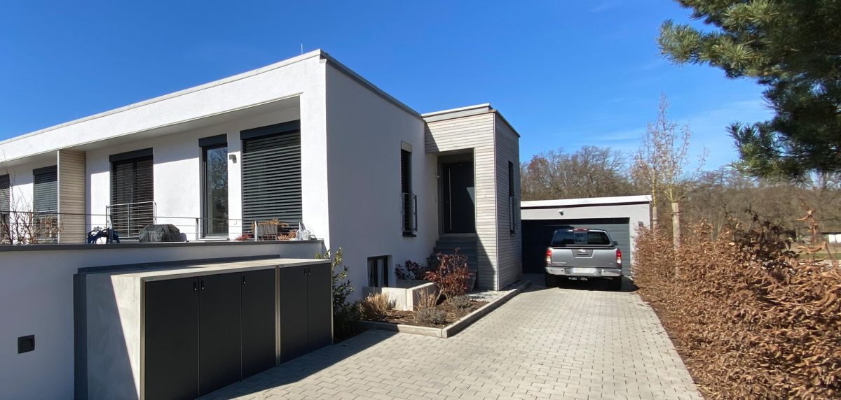 Modernes Einfamilienhaus mit Garage und gepflasterter Zufahrt