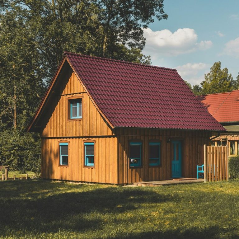 Haus verkaufen Neuhof an der Zenn: Holzhaus mit rotem Dach im Garten