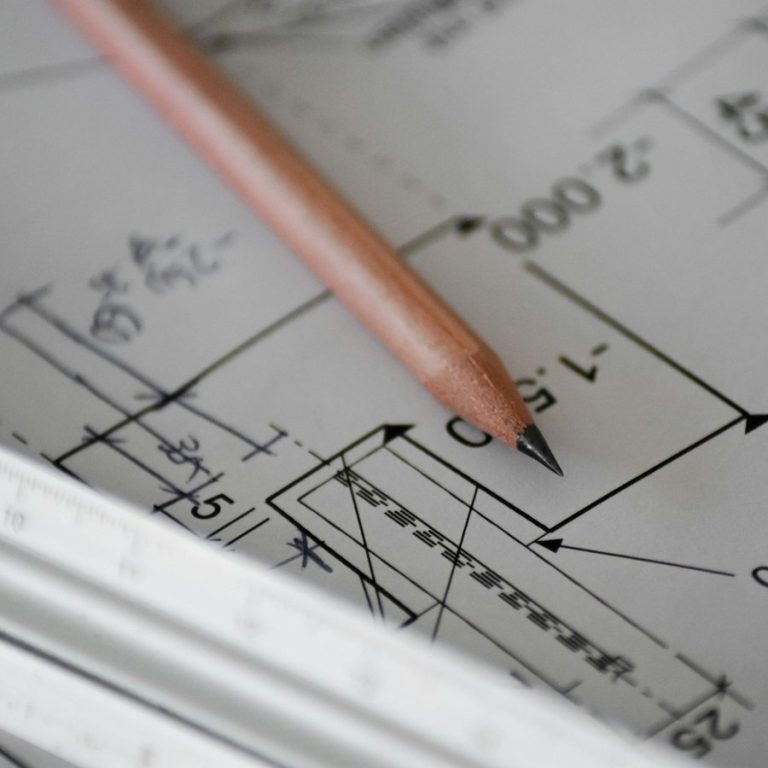 Immobilienbewertung Stein: Bleistift auf einem Bauplan